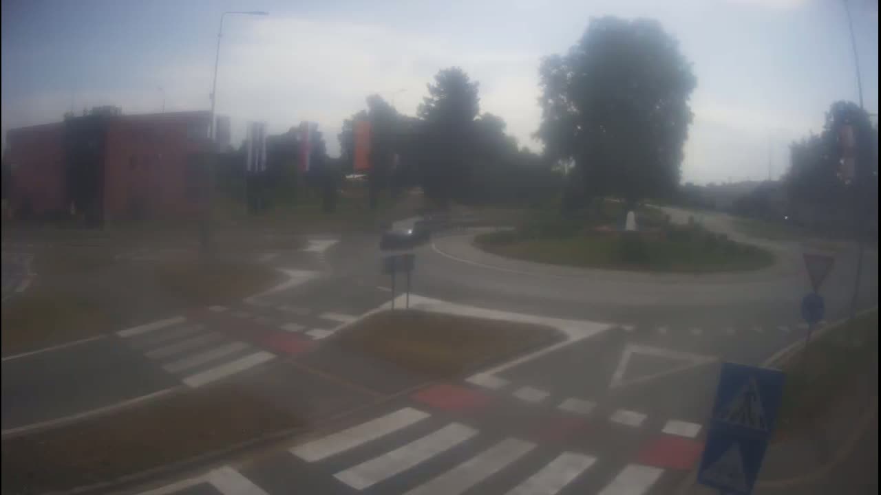 A car is navigating a roundabout on a hazy day.