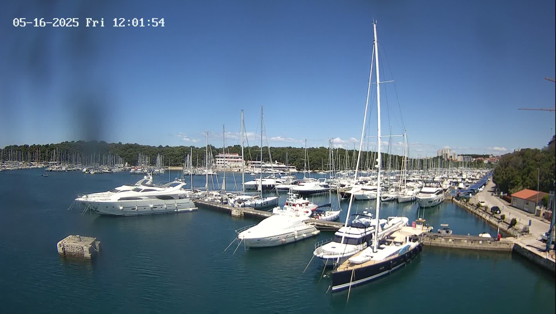 A marina filled with numerous yachts and sailboats on a sunny day.
