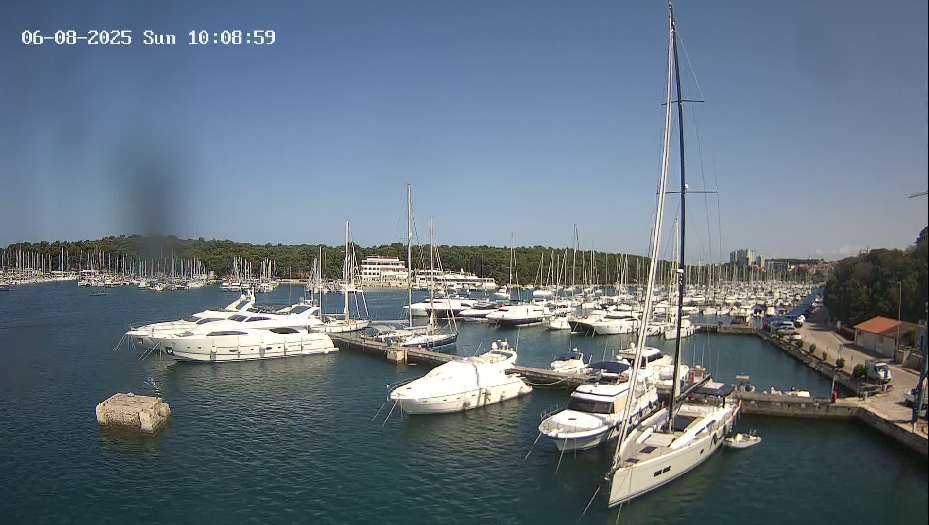 A marina filled with numerous yachts and sailboats on a sunny day.
