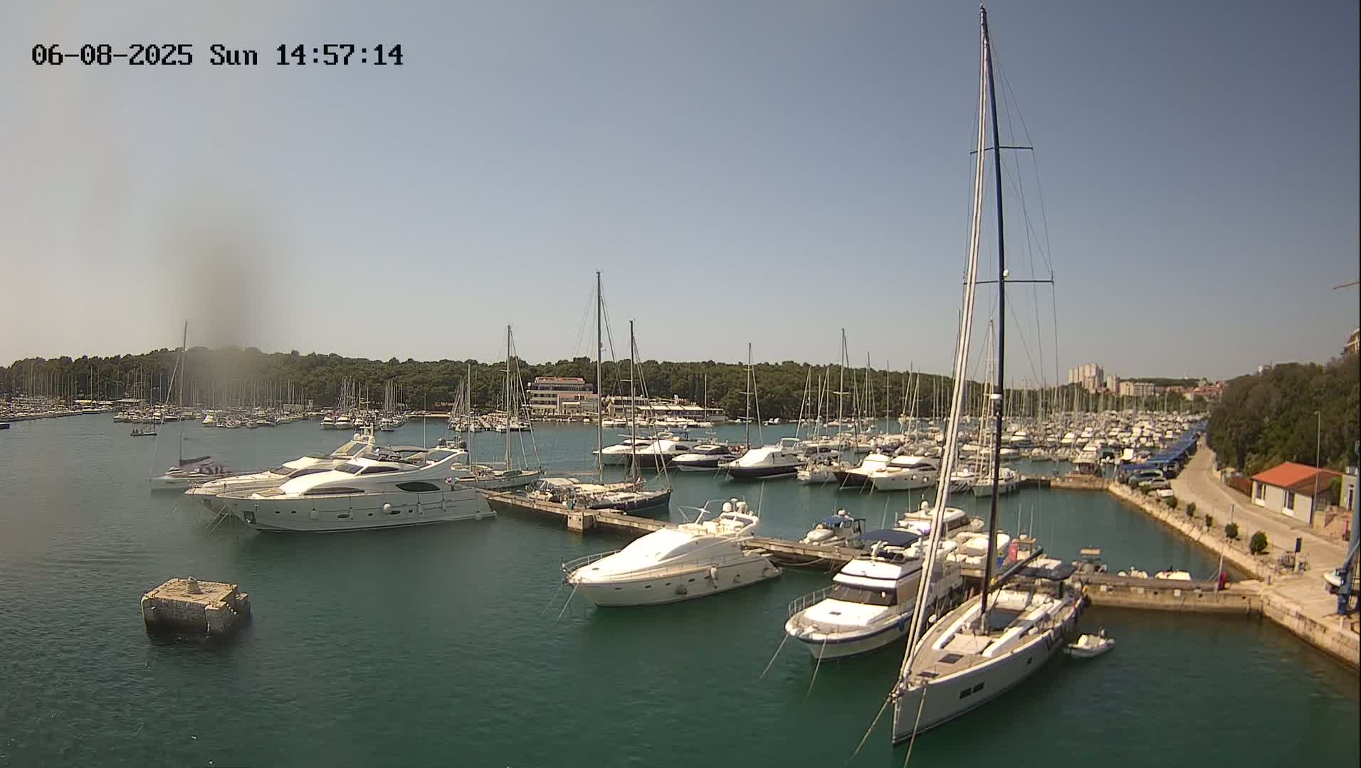 A marina filled with numerous yachts and sailboats on a sunny day.