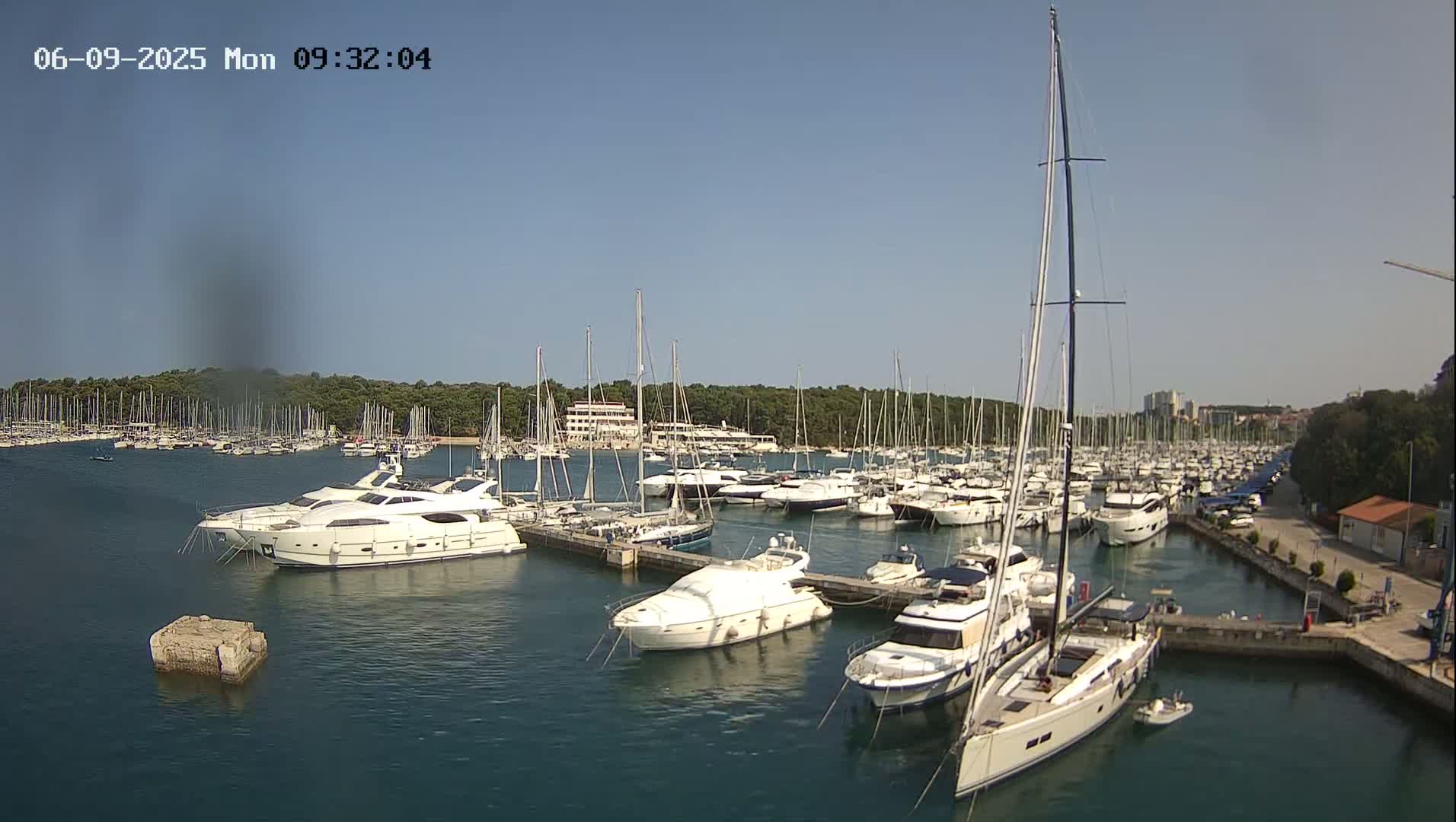 A marina filled with numerous yachts and sailboats on a sunny day.