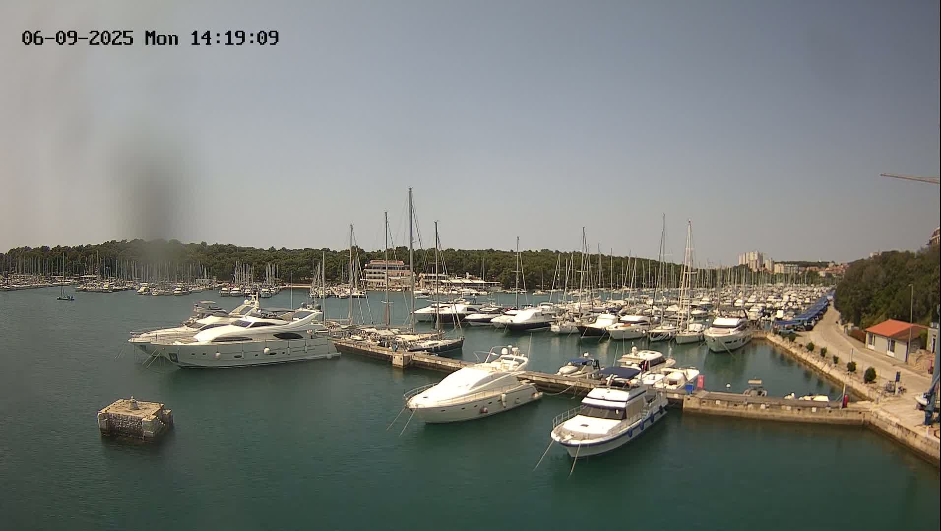 A marina filled with numerous yachts and sailboats on a sunny day.
