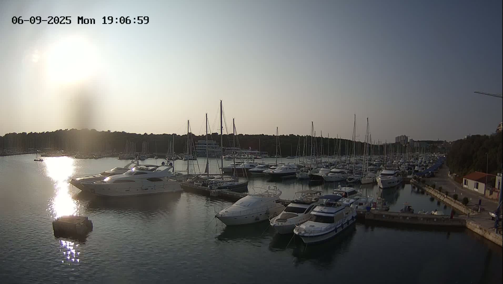 A marina filled with numerous yachts and sailboats under a partly sunny sky.