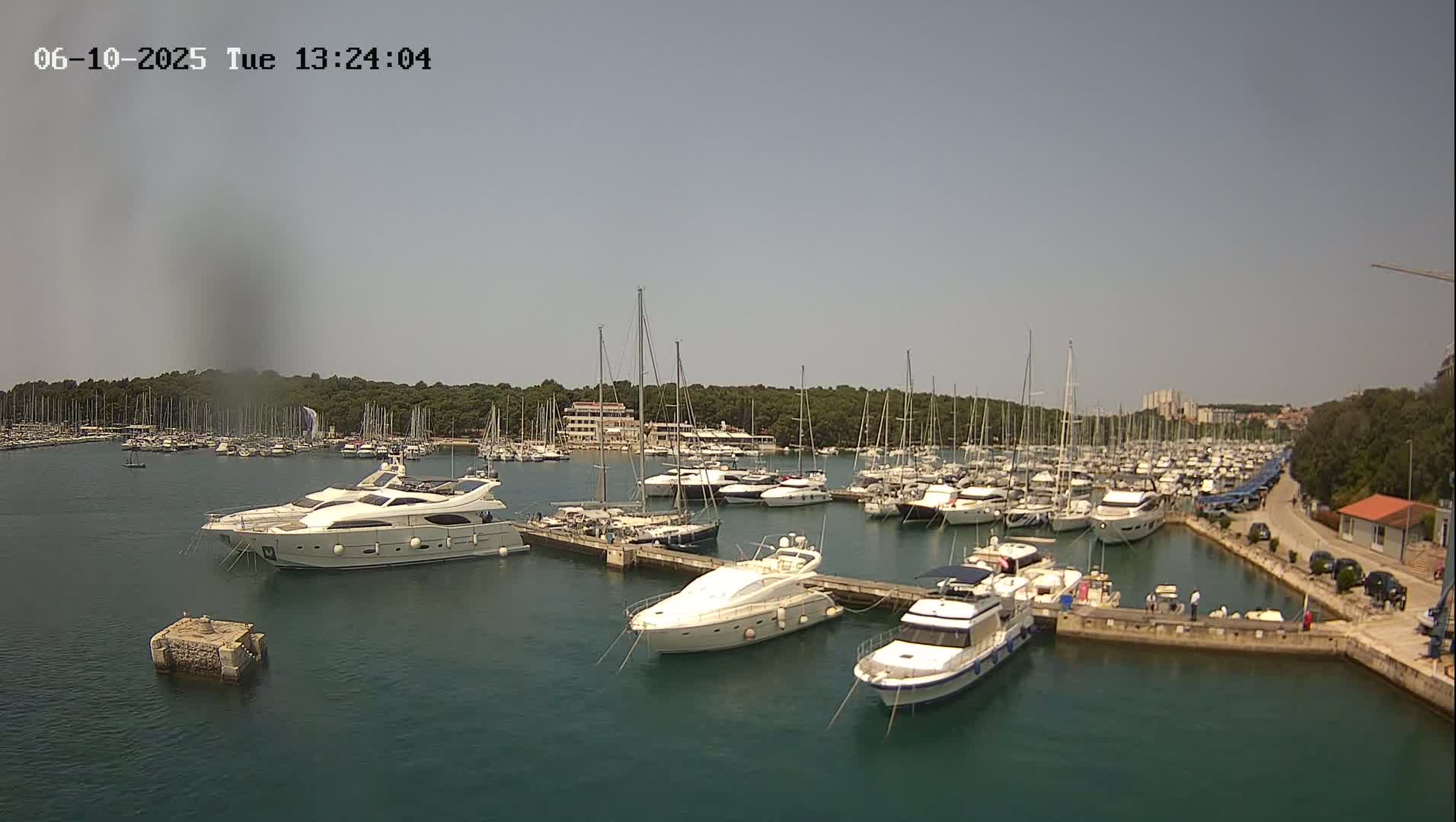 A marina filled with numerous yachts and sailboats on a sunny day.