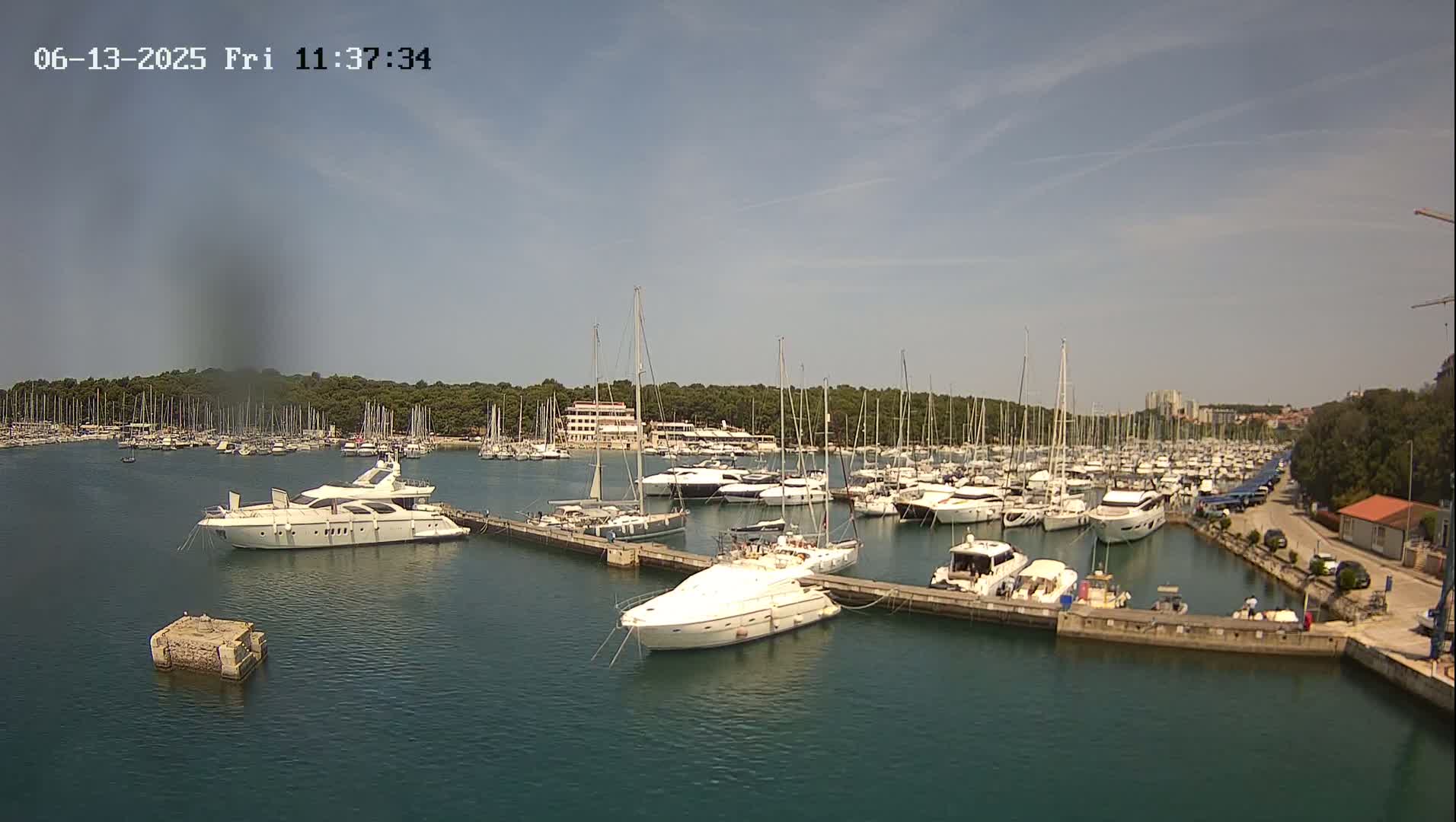 A marina filled with numerous yachts and sailboats on a sunny day.
