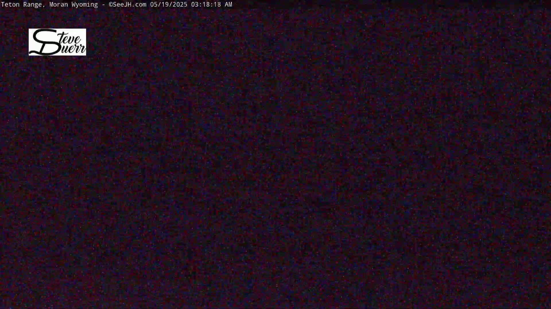 A dark, grainy image shows a mostly black screen with some slight variations in color.