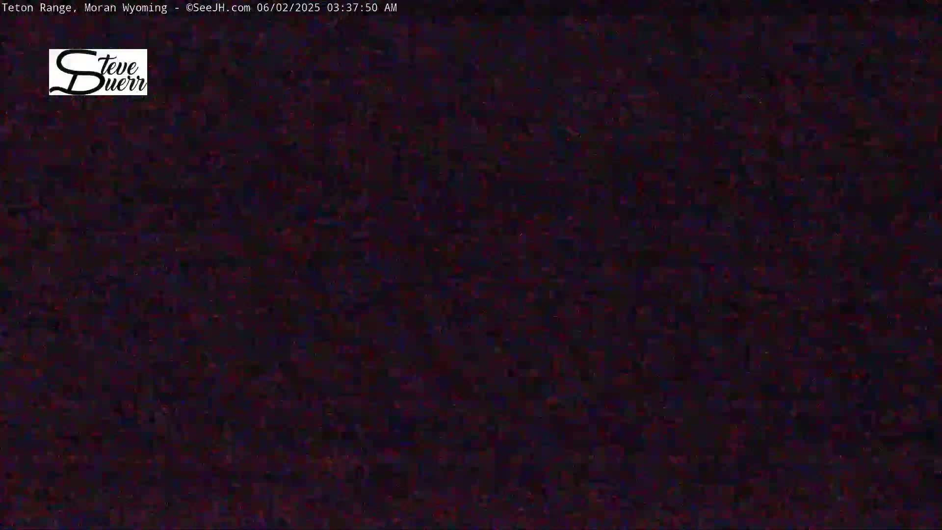 The image shows a dark, grainy, and blurry view of an outdoor scene at night.