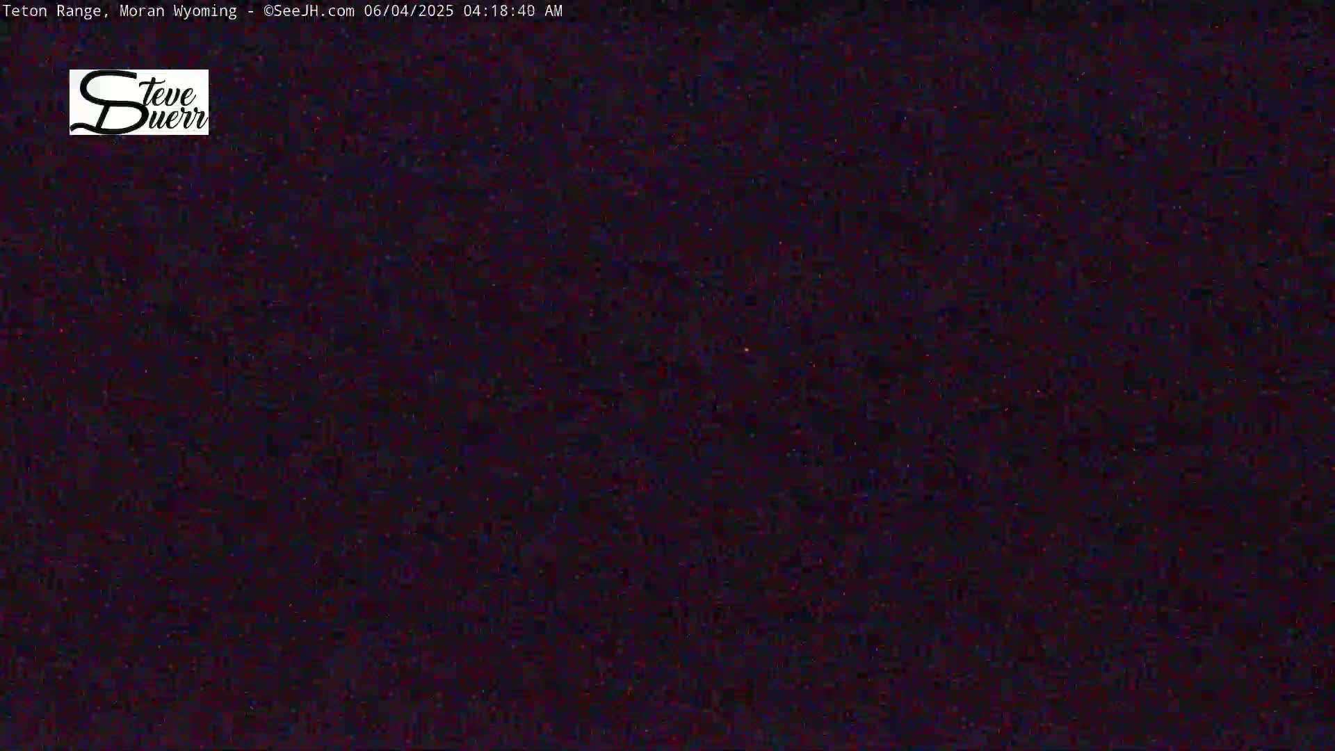 A nighttime outdoor image shows a dark, grainy view of the sky speckled with faint light.