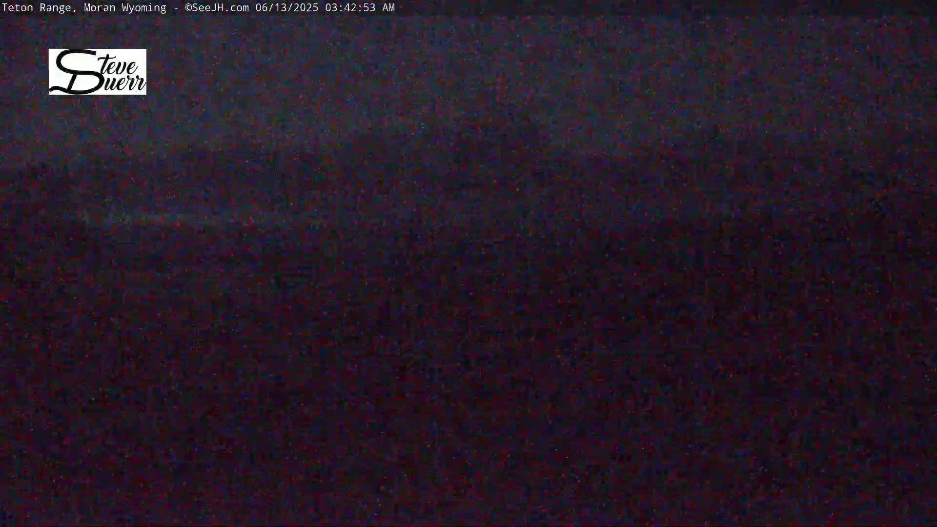A dark, possibly nighttime, outdoor scene shows a blurry, indistinct landscape under a dark sky.