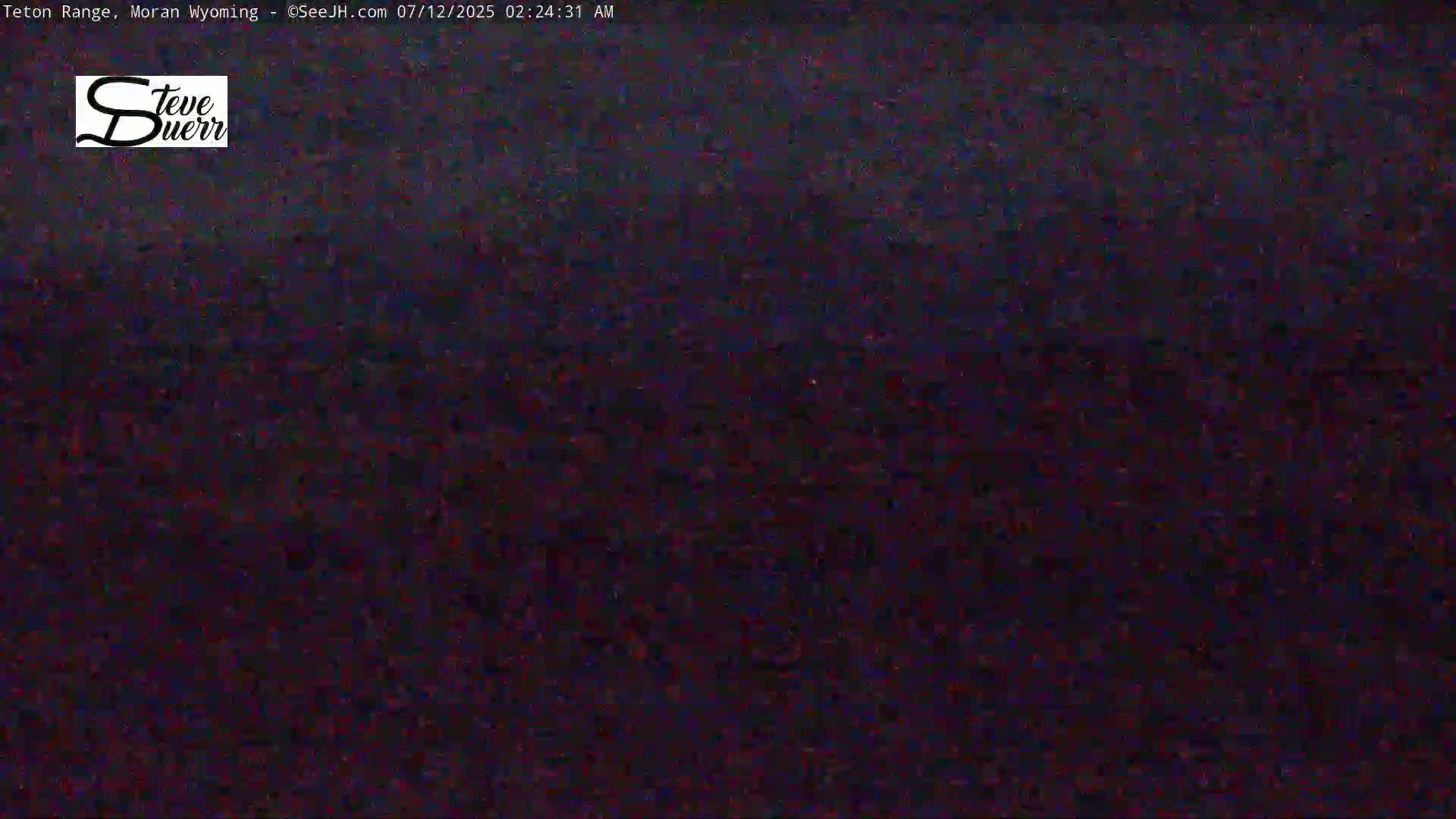 A dark, nighttime scene shows a blurry, indistinct landscape under a dark sky.