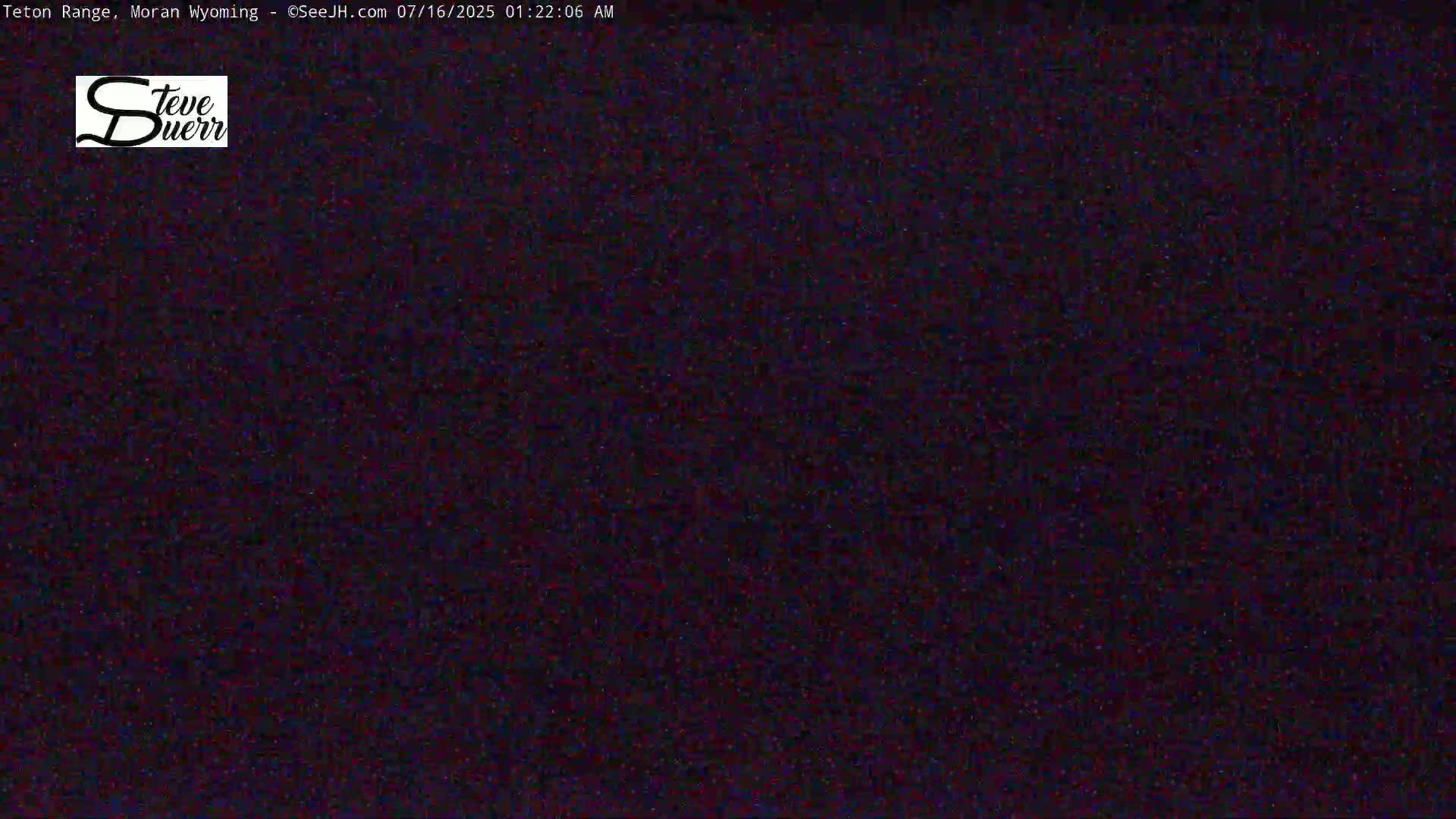 A dark, grainy image shows a mostly black scene under nighttime conditions.