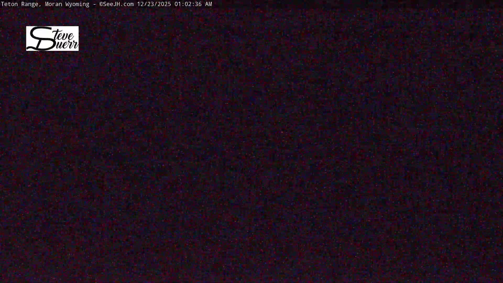The image shows an extremely dark outdoor scene on a clear night, with heavy digital noise obscuring any discernible features.