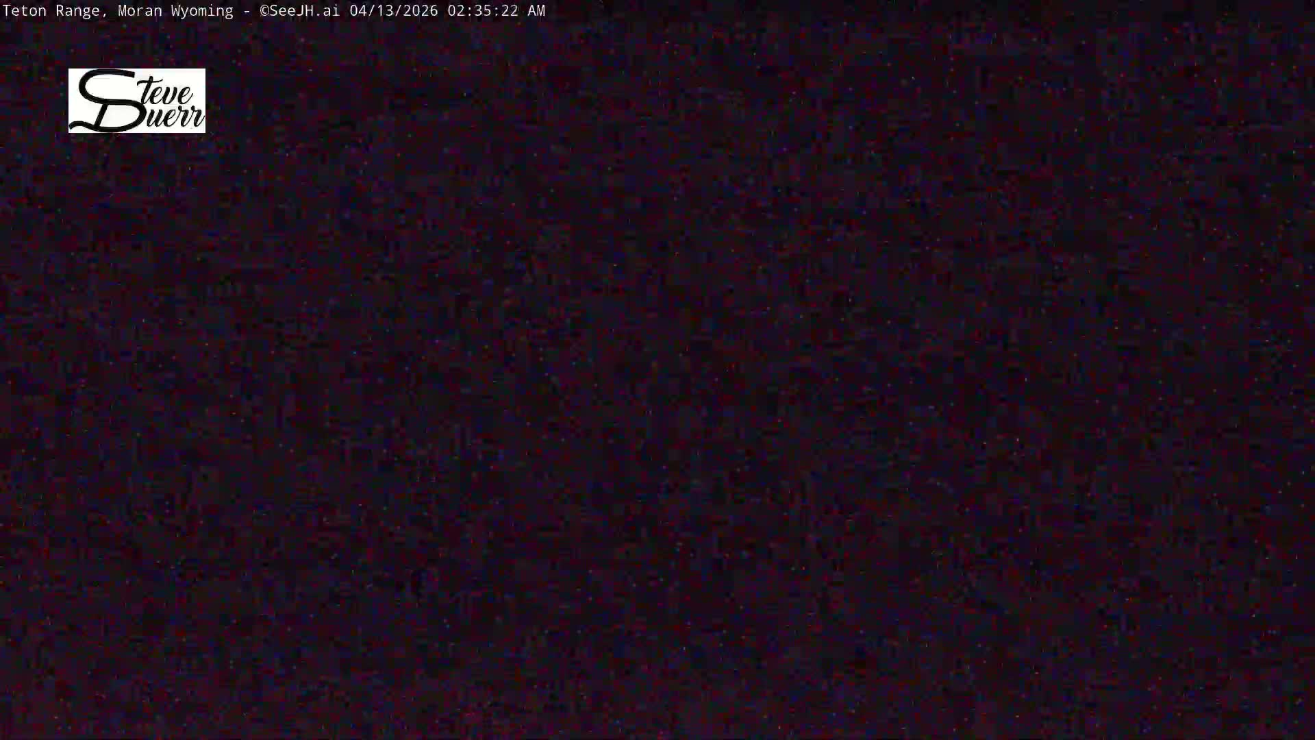 The image shows an extremely dark outdoor scene on a clear night, with heavy digital noise obscuring any discernible features.