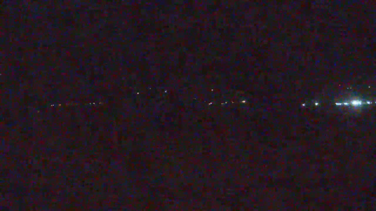 A distant line of faint lights is visible at night.
