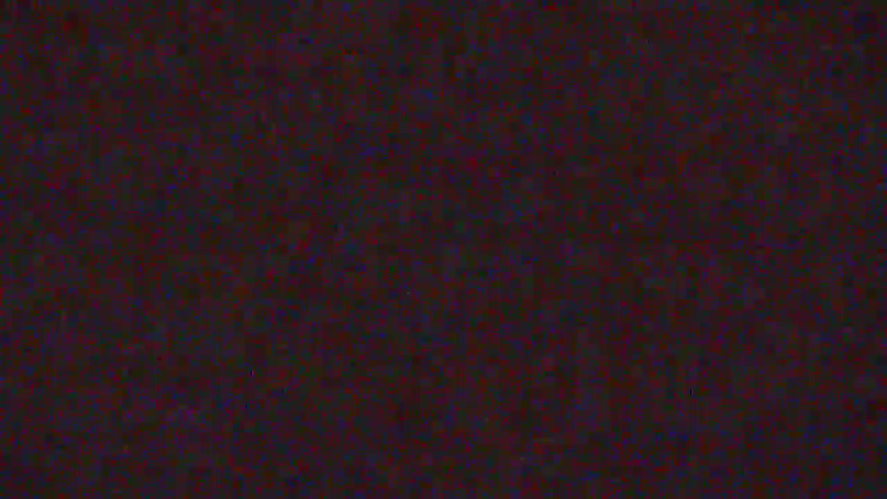 The image displays a dark, heavily pixelated and noisy field of mixed deep red, maroon, and dark blue colors, with no discernible objects or scenery.