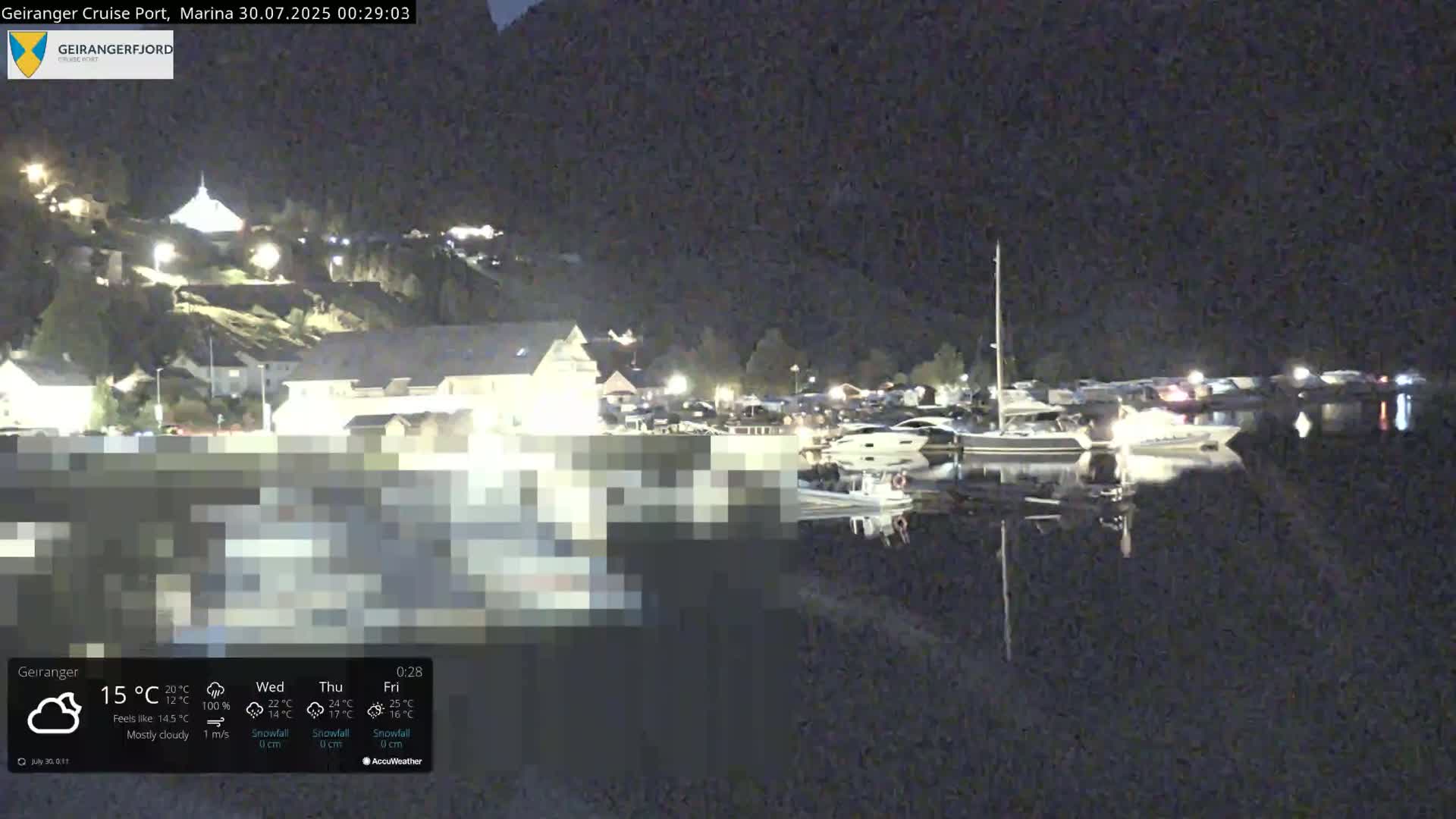A sunny view of a marina nestled between steep, green mountains, with several boats docked and a ferry visible in the distance.