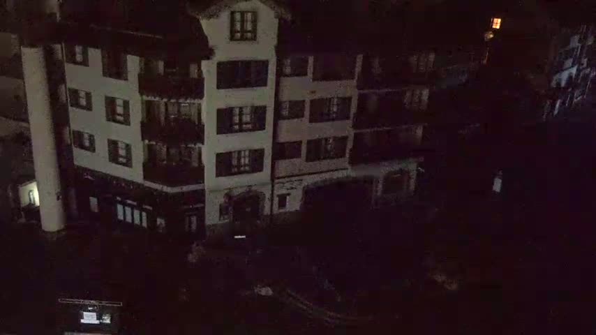 A multi-story building is seen at night, under dark conditions.