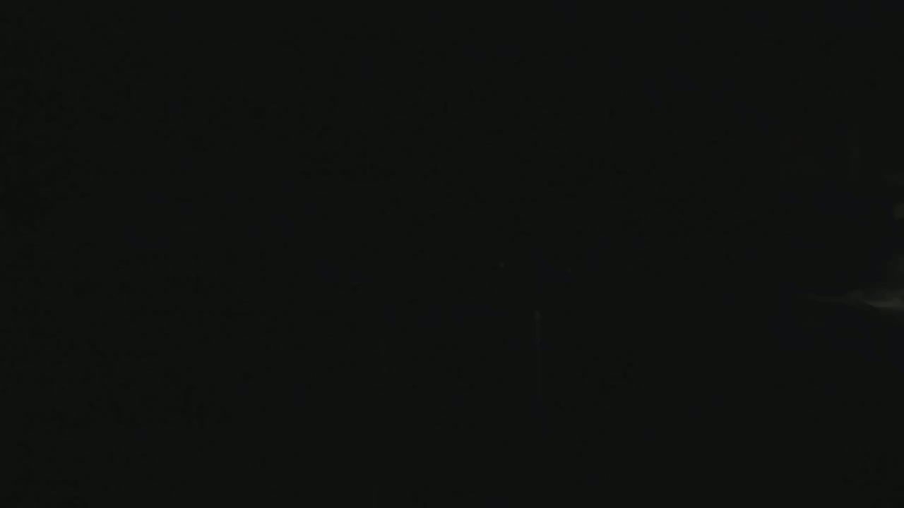 The image is almost entirely black, with a faint, blurry glow visible in the lower right corner.
