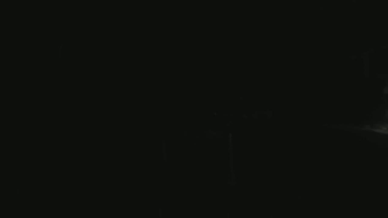 The image shows a dark, nighttime scene with a faintly visible bright area in the bottom right corner.