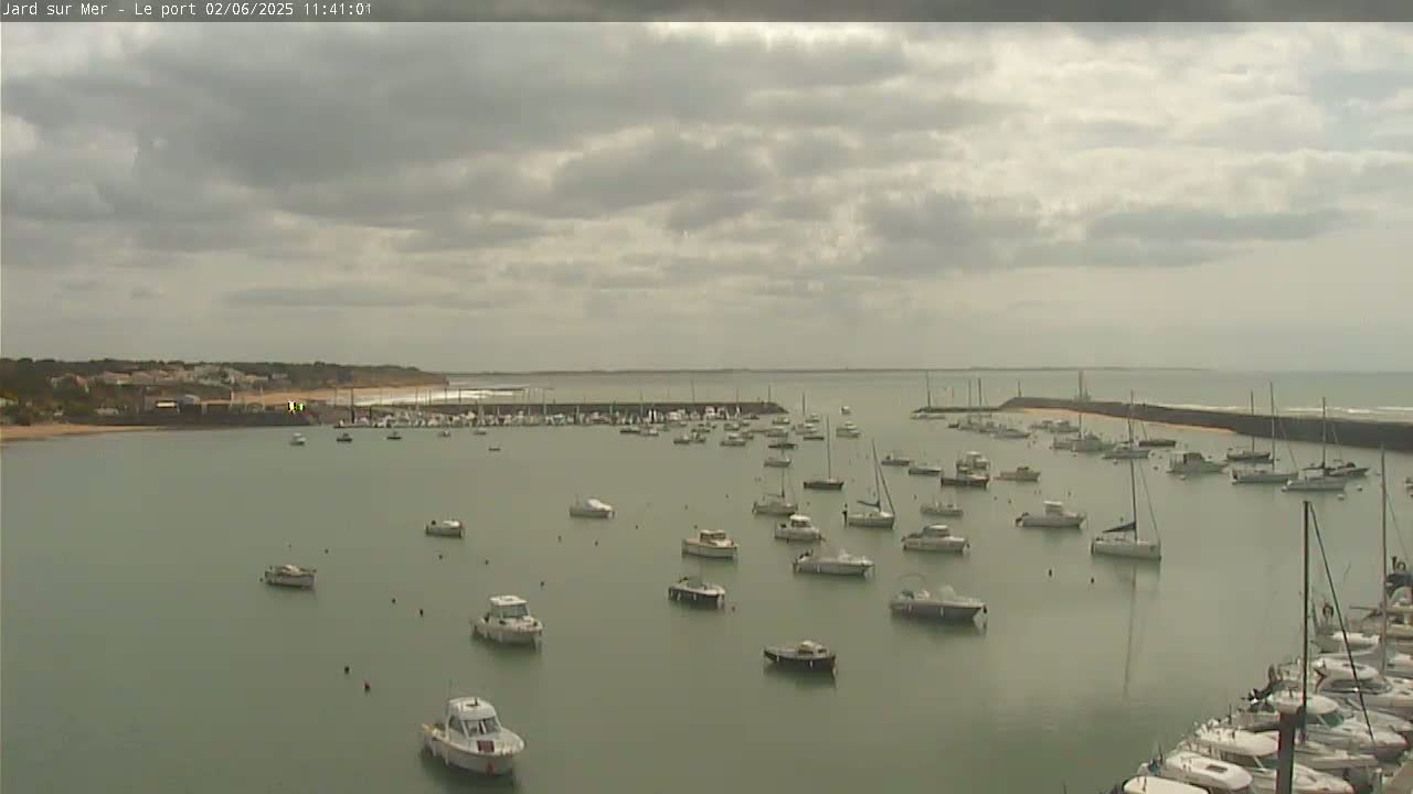A harbor filled with numerous boats under a cloudy sky.