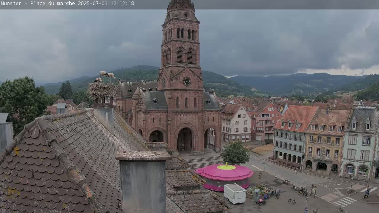 Munster,Place du Marché ( Market Square) & La Fontaine Lion Fountain / Église protestante (Protestant Church) Live Cam -  Colmar-Ribeauvillé, Haut-Rhin, Grand Est, France