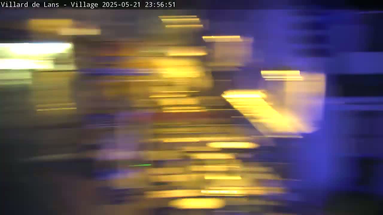 A blurry, nighttime image shows streaks of yellow and blue light, suggesting motion.