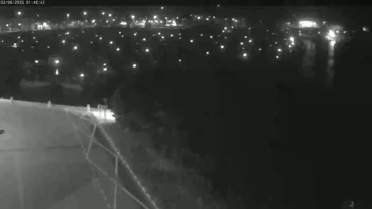 A nighttime, high-angle view shows numerous small, distant lights spread across a dark landscape.