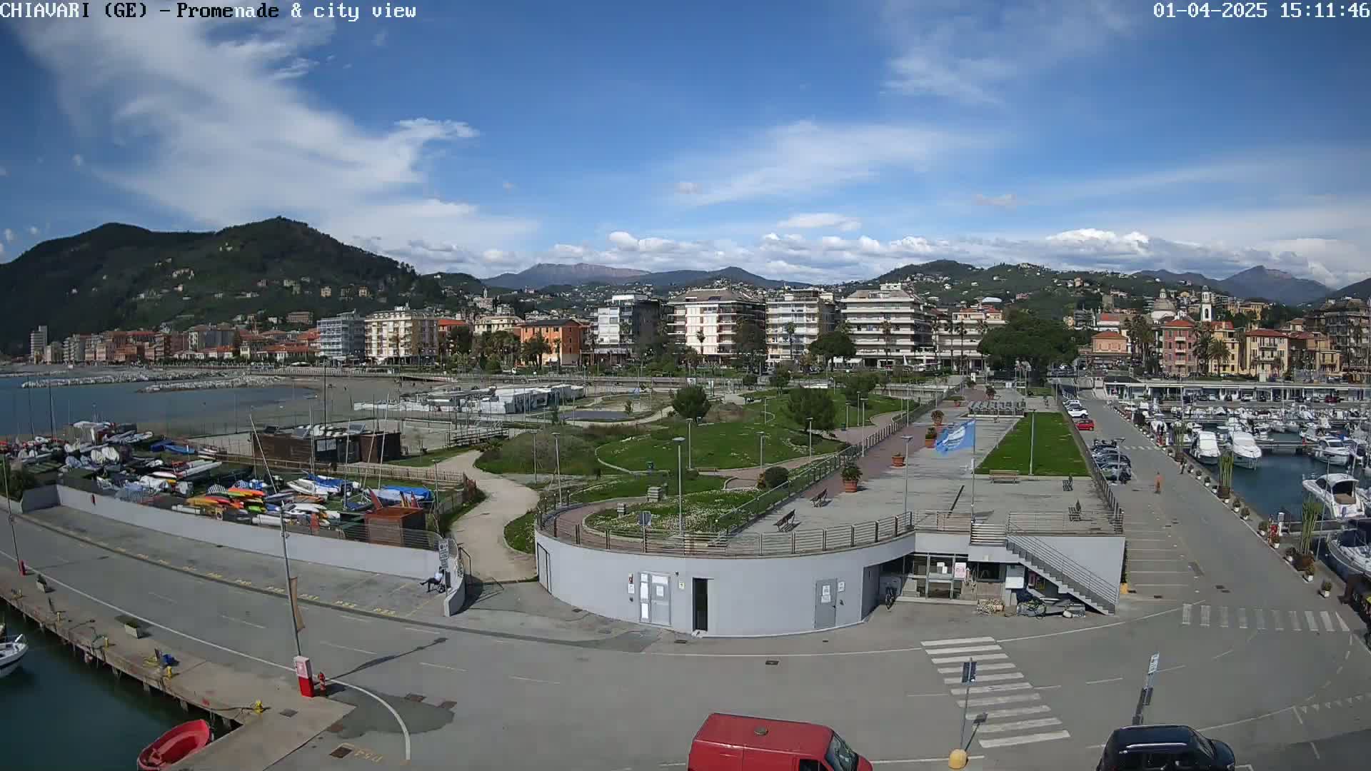 A coastal city with a marina, park, and residential buildings is shown under a mostly sunny sky with some scattered clouds.