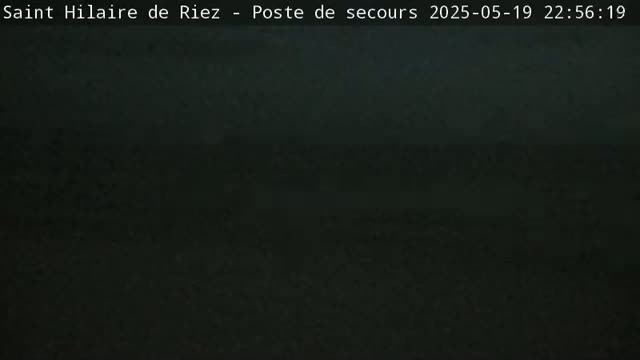 A dark, blurry image shows a mostly black landscape at night.
