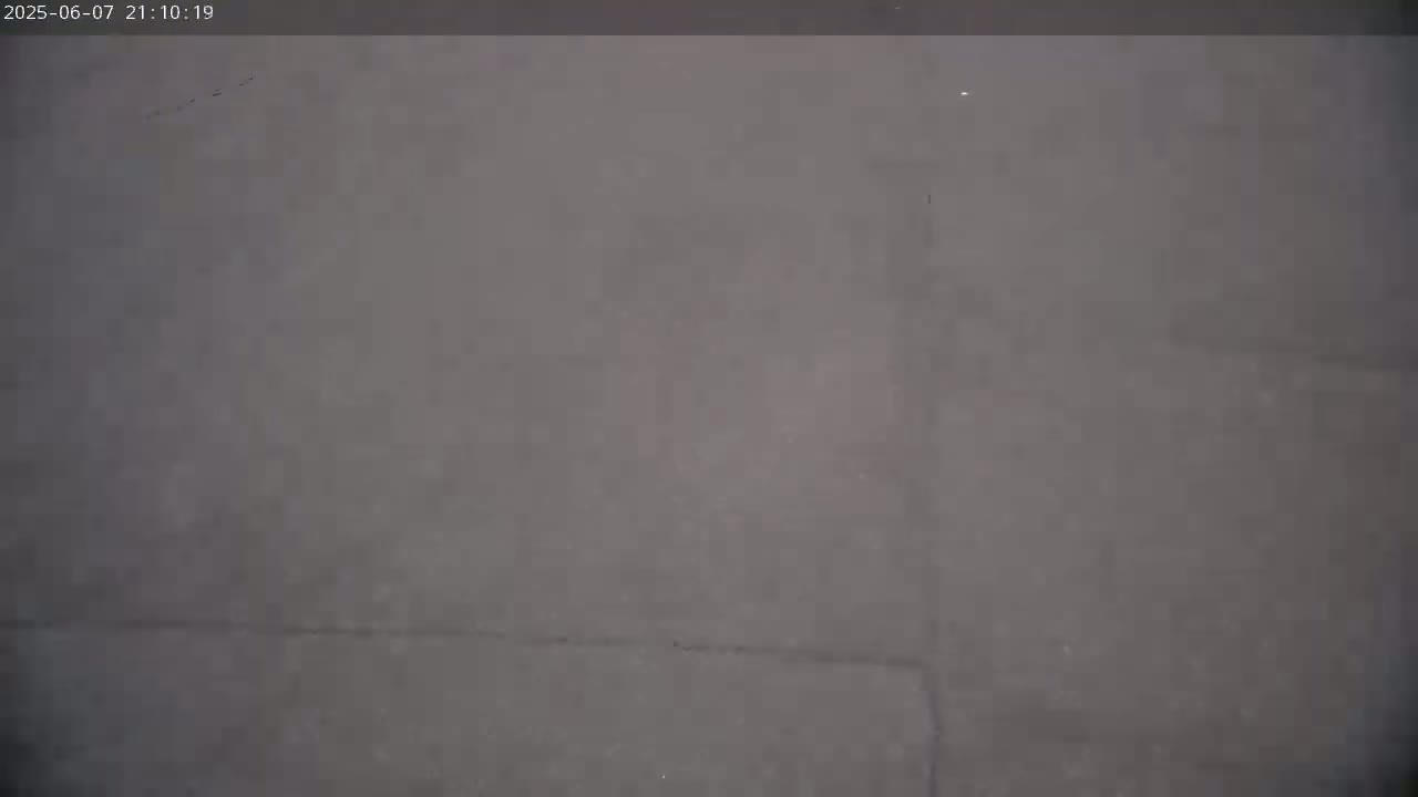The image shows a uniformly gray surface, possibly a wall or floor, under poor lighting conditions.