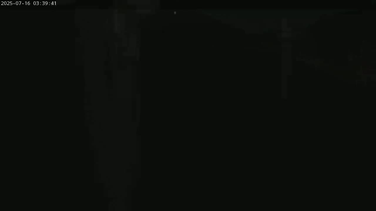 The image is almost entirely black, with very faint, indistinct shapes and a few specks of light.