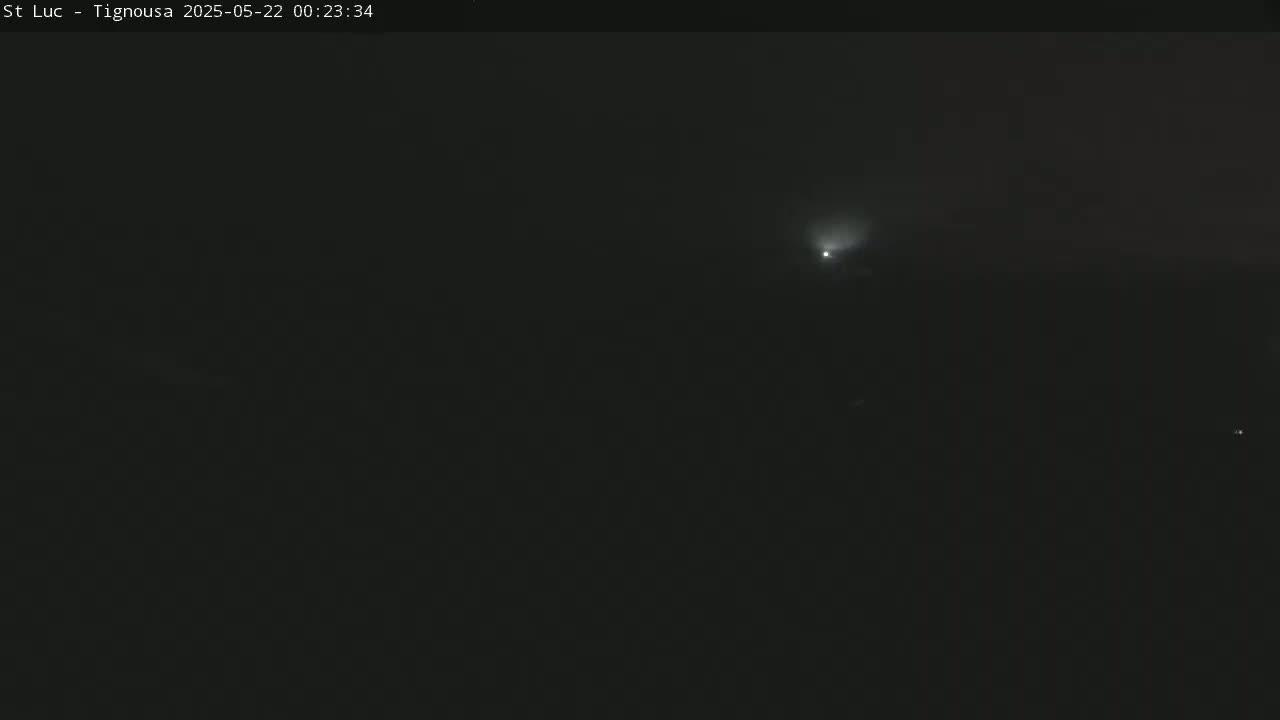A faint light streaks across a dark, nighttime sky.