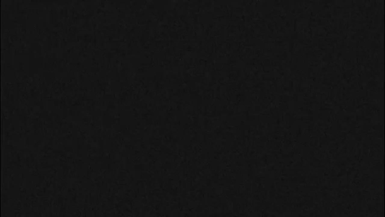 The image is completely black with a subtle, uniform texture, offering no discernible features or scenes.