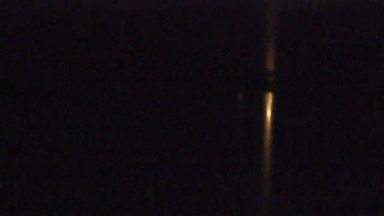 A blurry, vertical streak of light is visible in the center of a dark, nighttime scene.