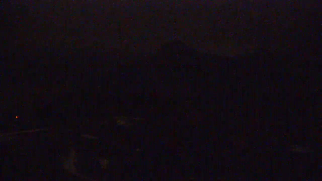 A very dark, possibly nighttime, outdoor scene shows a mostly indistinct landscape under a dark sky.