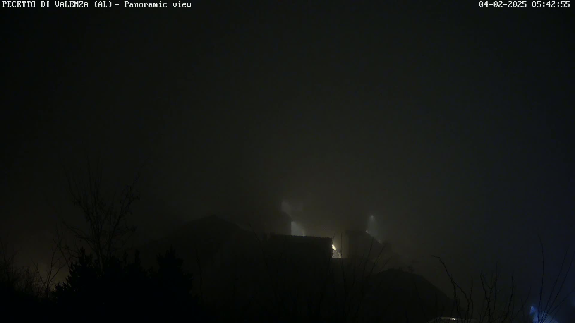 A dimly lit structure is partially obscured by heavy fog at night.