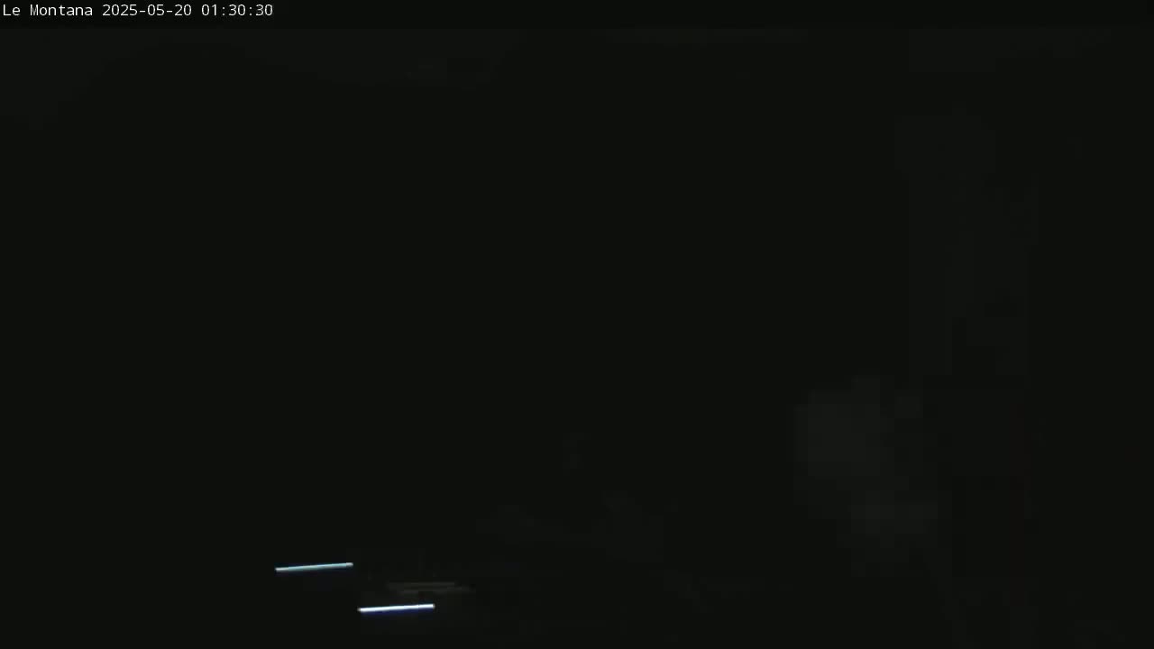 The image shows a dark scene at night with faint streaks of light possibly from vehicle headlights in the bottom portion of the frame.