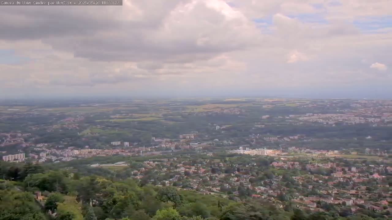 A sprawling suburban landscape extends to the horizon under a partly cloudy sky.