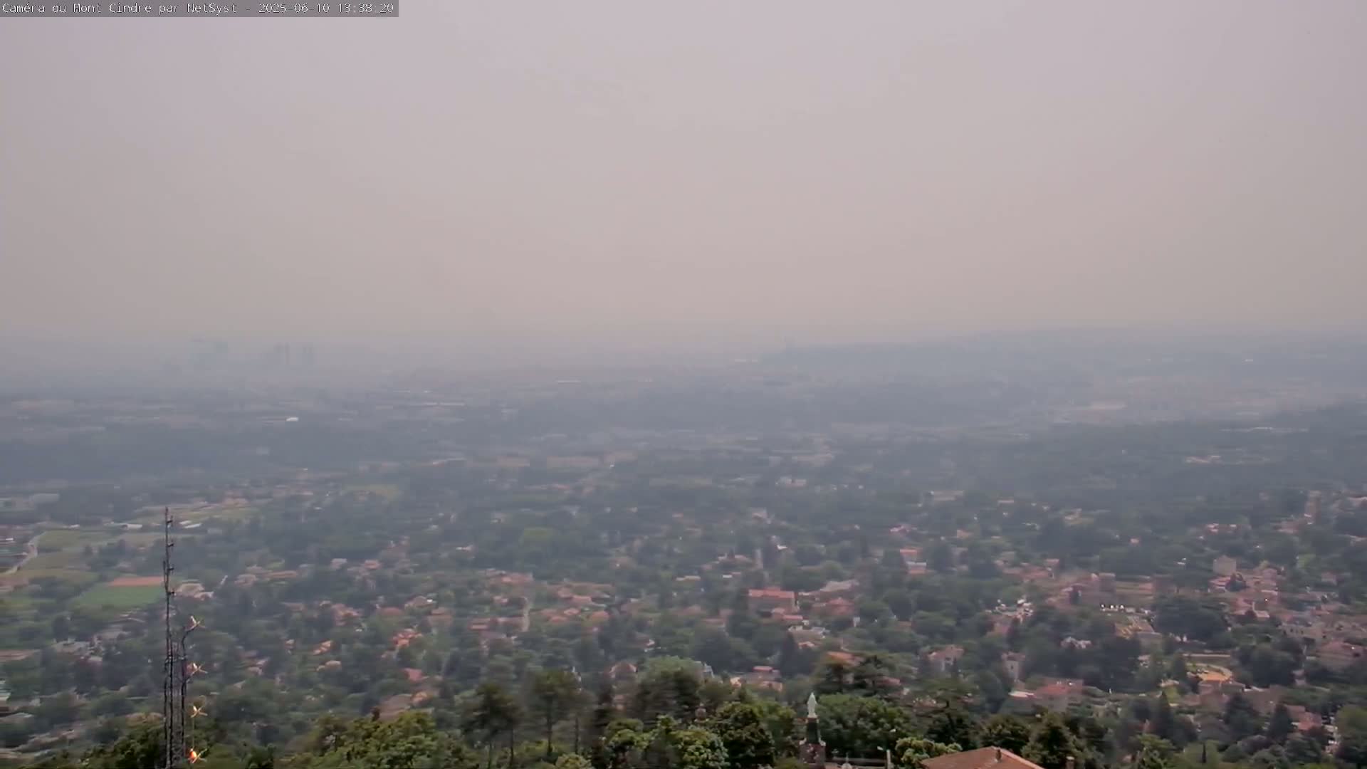 A hazy, distant view of a sprawling suburban area with trees and buildings extending to the horizon.