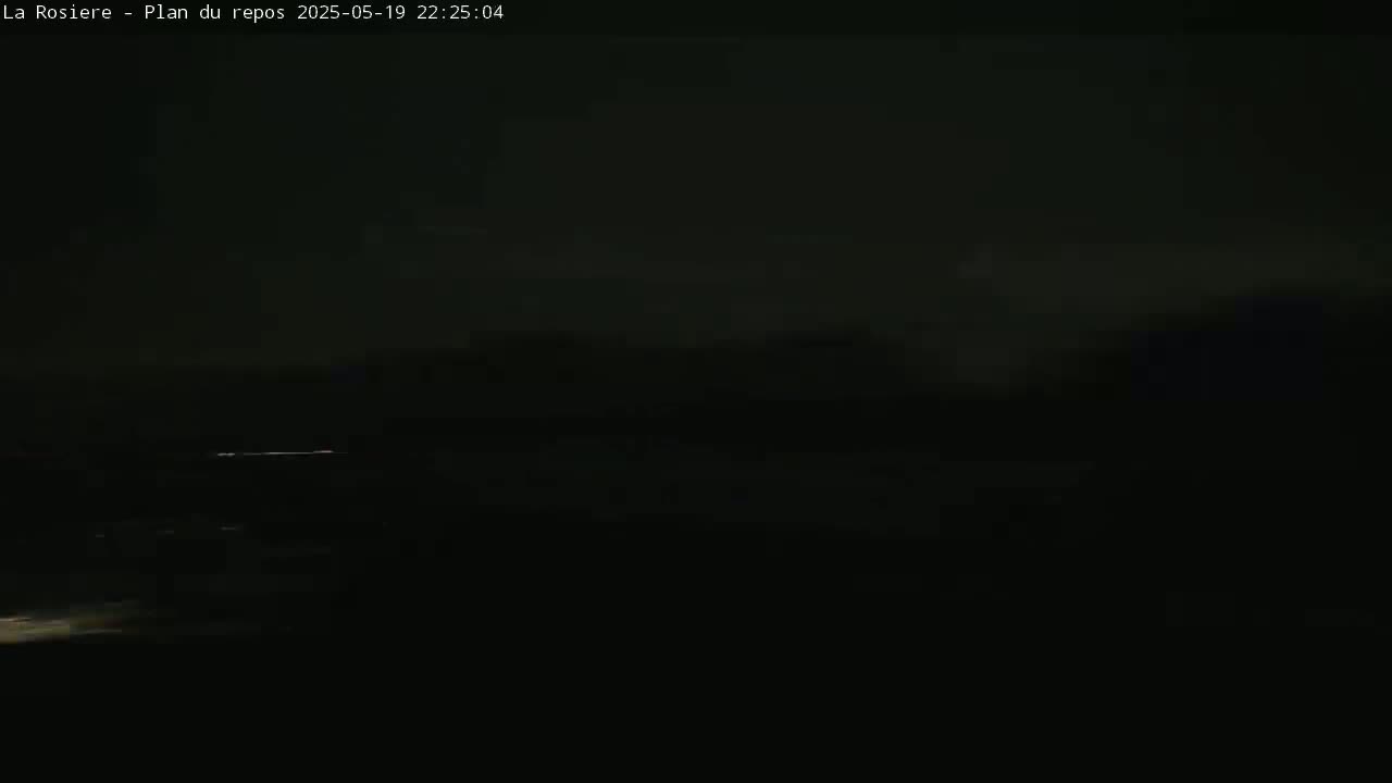A dark, nighttime outdoor scene shows a faint, horizontal line of light in the distance.
