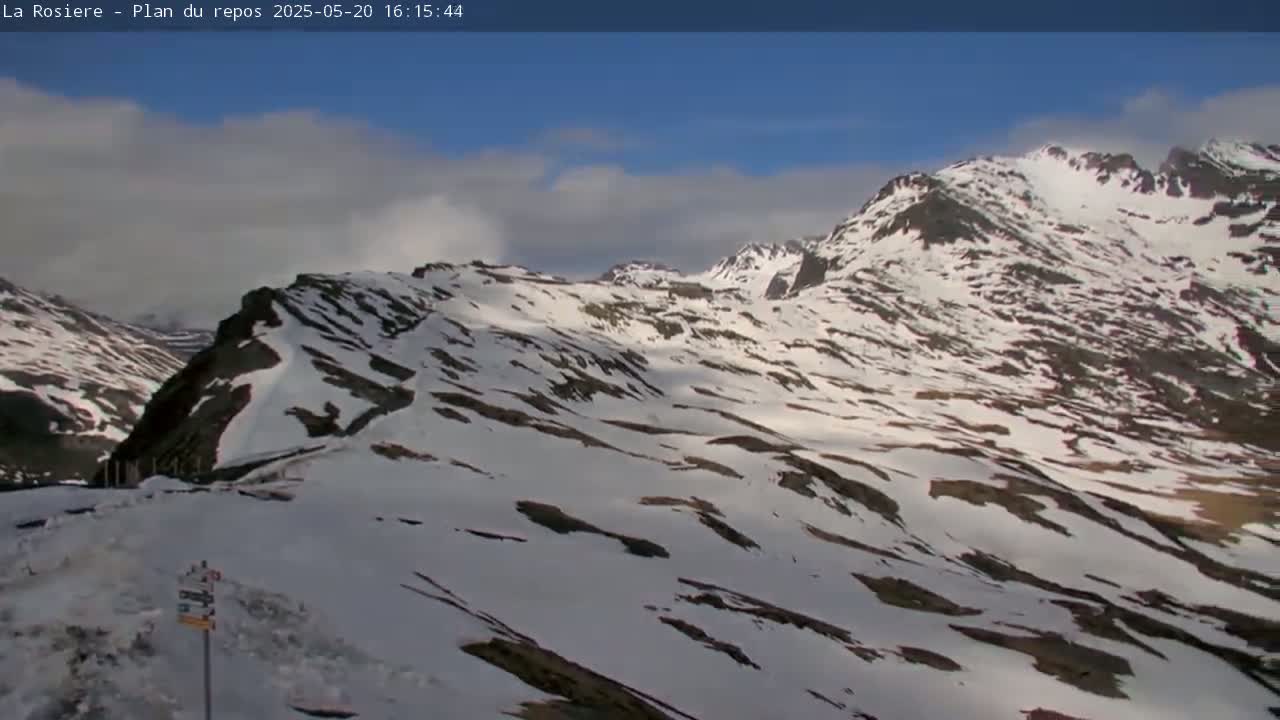 A snow-covered mountain range is visible under a partly cloudy sky.