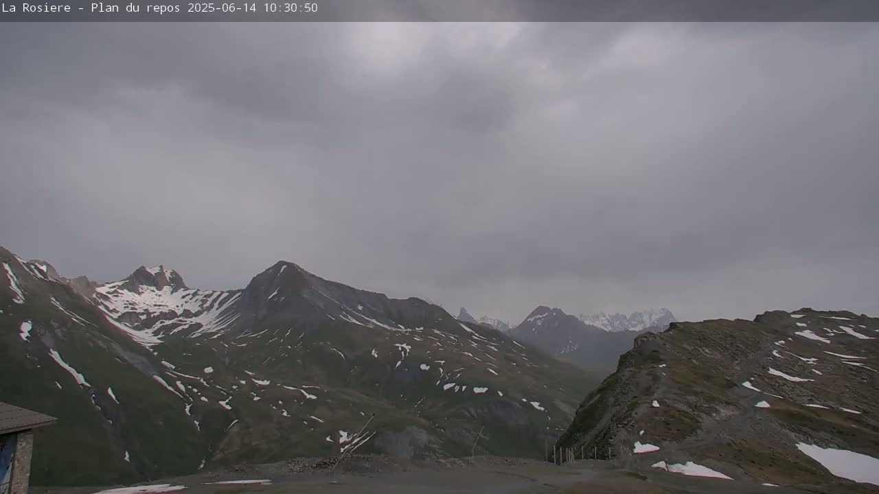 A view of snow-capped mountains under an overcast sky.