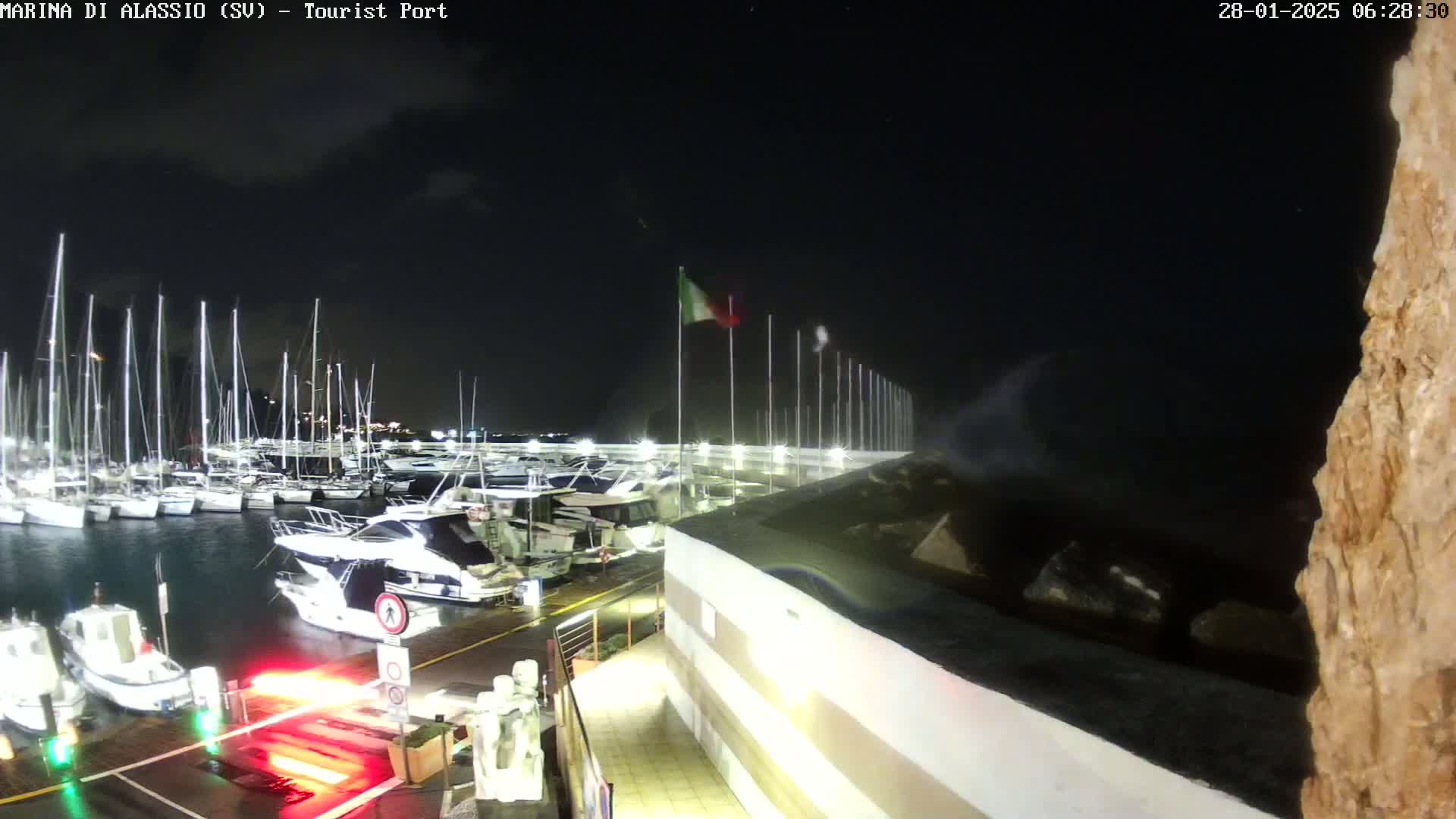 A nighttime view of a marina filled with boats under a dark sky.