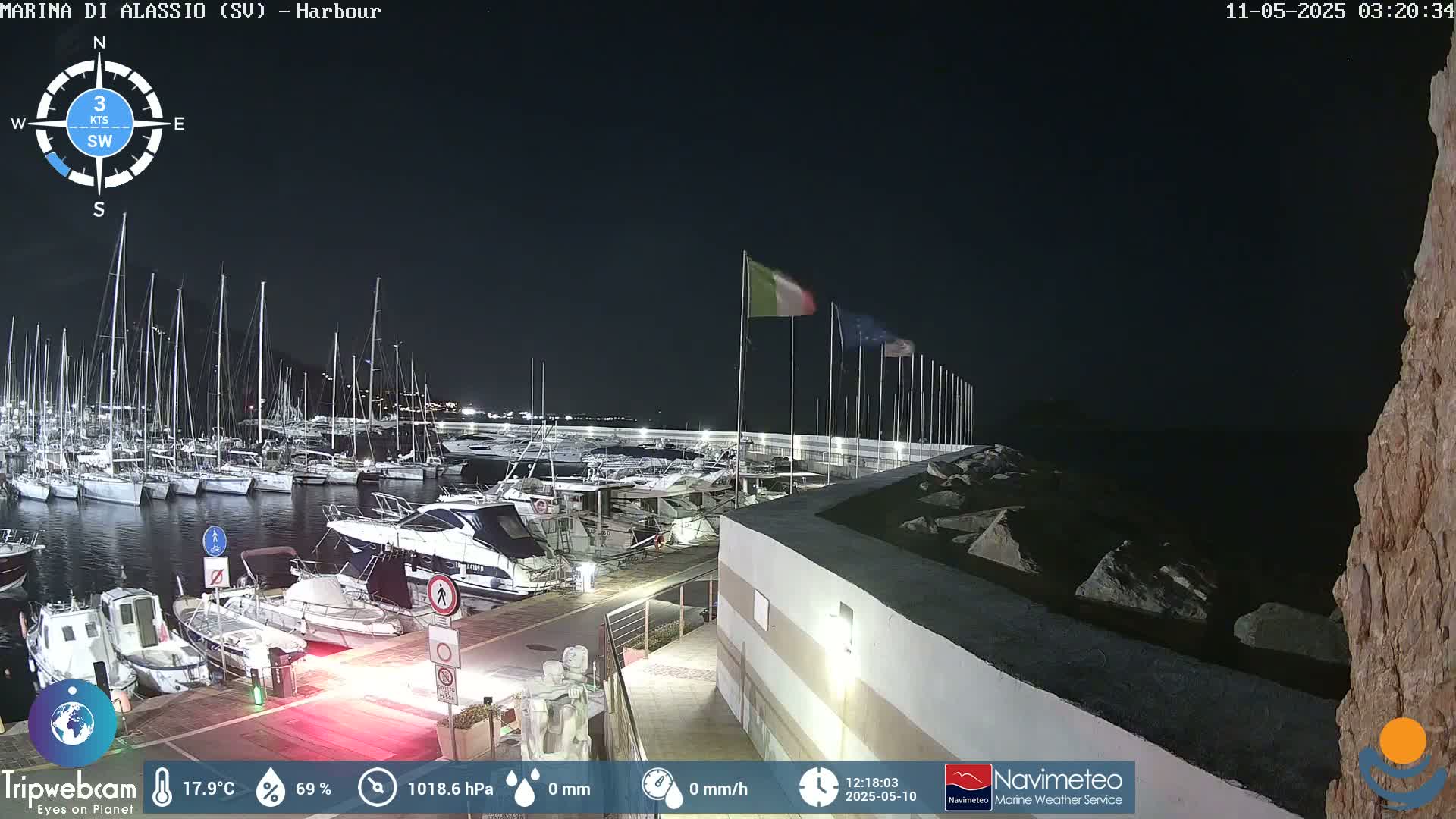 A nighttime harbor filled with numerous boats, under a clear, dark sky.