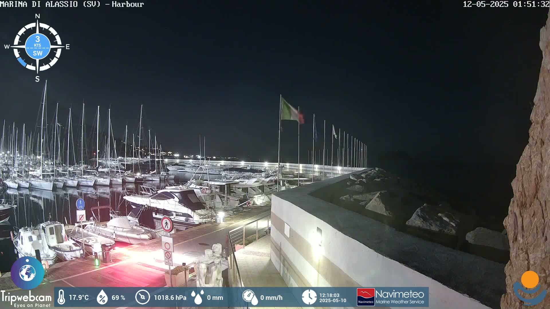 A nighttime view of a harbor filled with numerous boats, under a clear, dark sky.