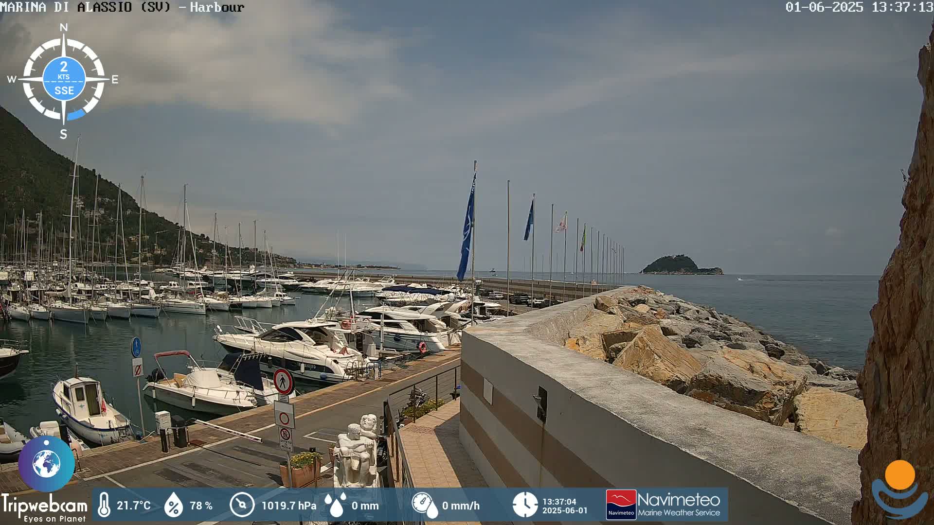 A harbor filled with numerous boats is situated under a partly cloudy sky.