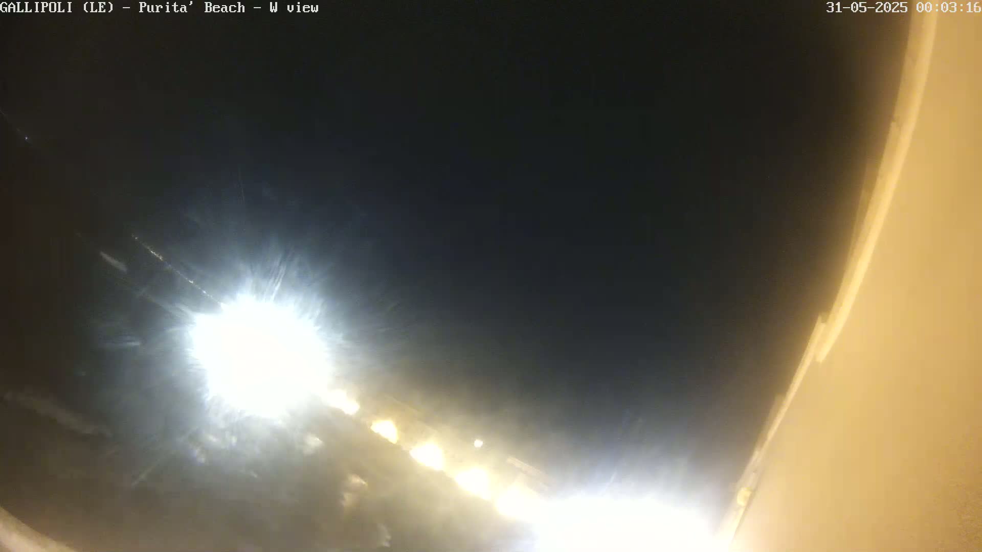 A nighttime view of bright lights and a dark sky, possibly at a beach.