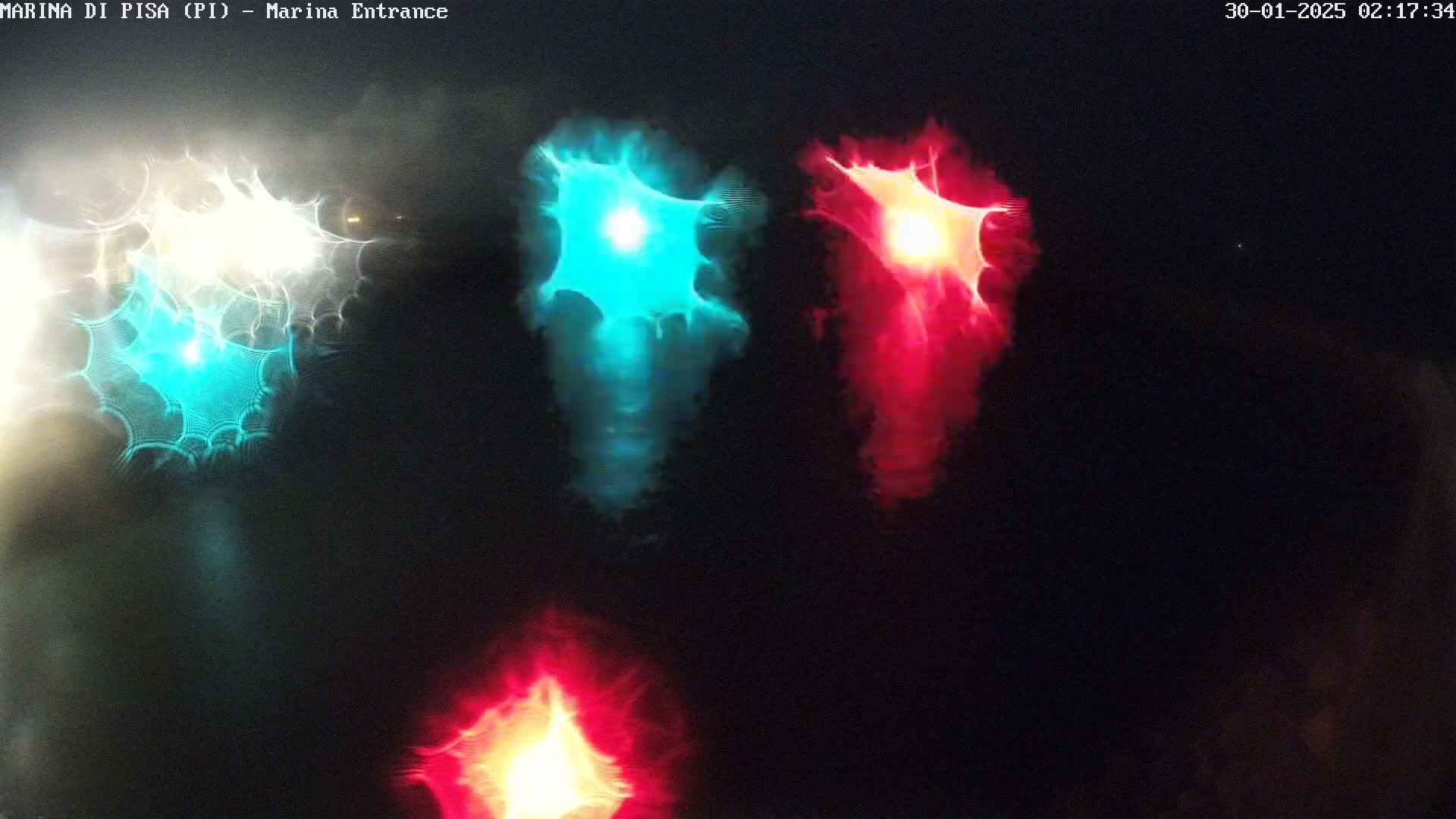 Blurred lights of teal, red, and white are visible at night through what appears to be a rain-streaked window.
