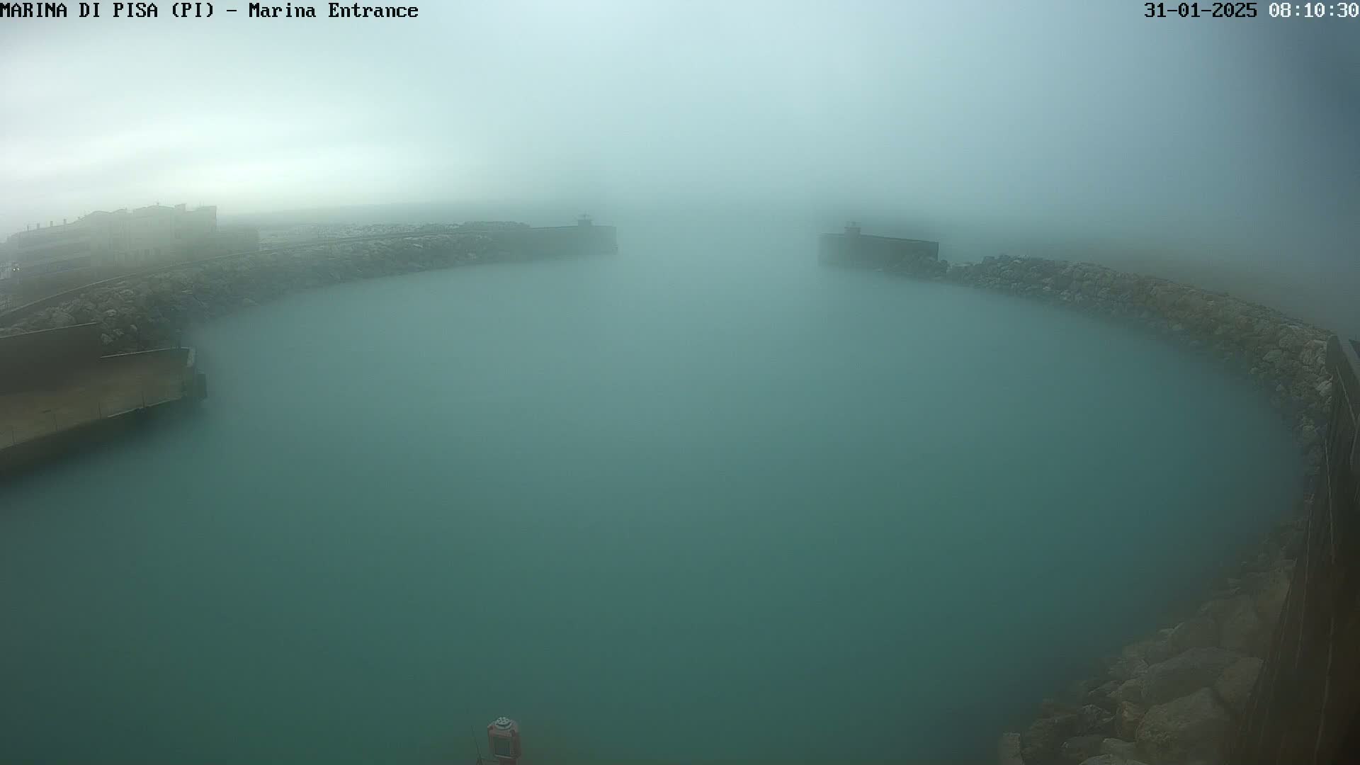 A foggy harbor entrance is visible, with teal water and stone walls partially obscured by the thick fog.