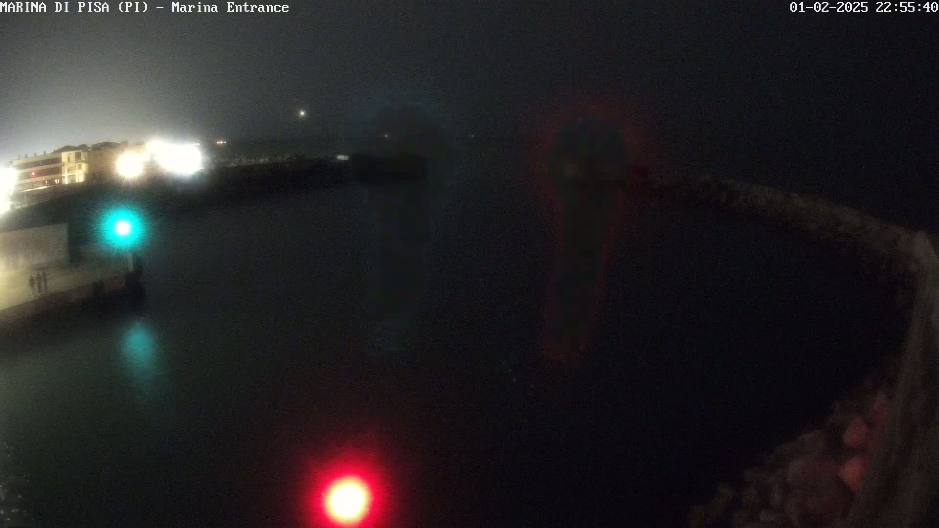 A nighttime view of a dark harbor with faintly visible lights on a foggy night.
